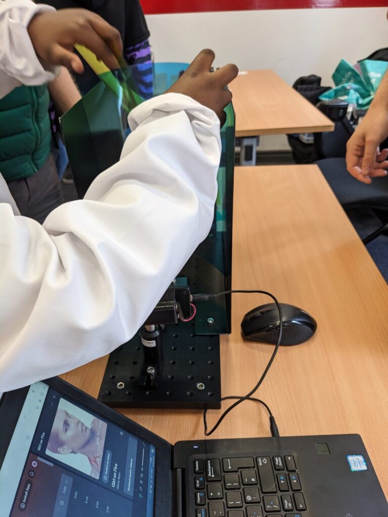 Children put a filter in the beam of the laser communications system at Be Curious 2024