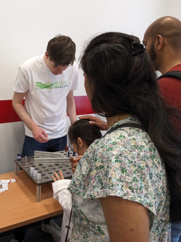Thomas Gill explains the laser maze game to children at Be Curious 2024