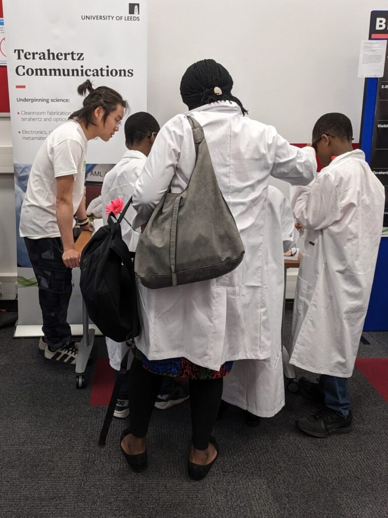 Researcher explains different coloured light to children at Be Curious 2024