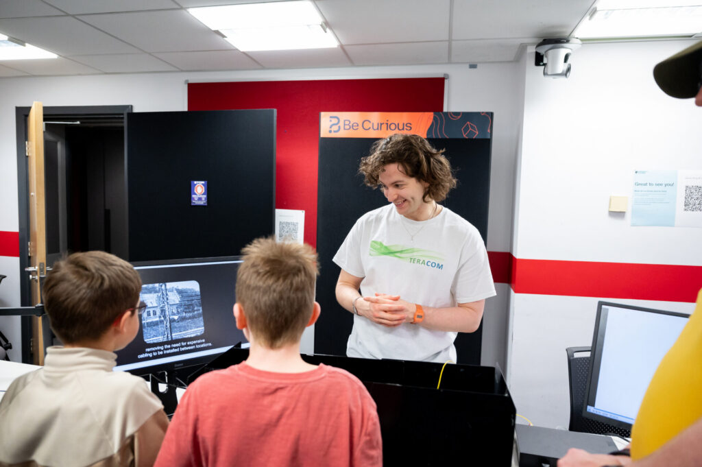 James demonstrating the laser comms system two two small boys